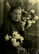 Druga połowa lat 30. do 1941, Kozienice, Polska.
Portret dziewczyny z kwiatami.
Zdjęcie wykonane w atelier fotograficznym żydowskiego fotografa Chaima Bernemana. Przed wojną zakład mieścił się w Kozienicach na rogu ulic Warszawskiej i Maciejowickiej, przed wybuchem wojny albo już w czasie niemieckiej okupacji  został przeniesiony na ulicę Lubelską 13. Cała kolekcja jest datowana na okres od drugiej połowy lat 30-tych do roku 1941, kiedy Chaim Berneman wraz z rodziną został zesłany do obozu pracy w Wolanowie. Berneman zmarł po ucieczce z obozu.
Fot. Chaim Berneman (Chaim Berman), zbiory Ośrodka KARTA