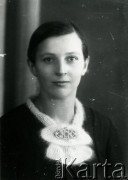 Druga połowa lat 30. do 1941, Kozienice, Polska.
Portret młodej kobiety w moherowym szaliku spiętym broszką.
Zdjęcie wykonane w atelier fotograficznym żydowskiego fotografa Chaima Bernemana. Przed wojną zakład mieścił się w Kozienicach na rogu ulic Warszawskiej i Maciejowickiej, przed wybuchem wojny albo już w czasie niemieckiej okupacji  został przeniesiony na ulicę Lubelską 13. Cała kolekcja jest datowana na okres od drugiej połowy lat 30-tych do roku 1941, kiedy Chaim Berneman wraz z rodziną został zesłany do obozu pracy w Wolanowie. Berneman zmarł po ucieczce z obozu.
Fot. Chaim Berneman (Chaim Berman), zbiory Ośrodka KARTA
