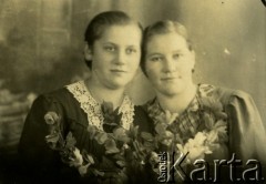 Druga połowa lat 30. do 1941, Kozienice, Polska.
Portret dwóch dziewczyny z kwiatami.
Zdjęcie wykonane w atelier fotograficznym żydowskiego fotografa Chaima Bernemana. Przed wojną zakład mieścił się w Kozienicach na rogu ulic Warszawskiej i Maciejowickiej, przed wybuchem wojny albo już w czasie niemieckiej okupacji  został przeniesiony na ulicę Lubelską 13. Cała kolekcja jest datowana na okres od drugiej połowy lat 30-tych do roku 1941, kiedy Chaim Berneman wraz z rodziną został zesłany do obozu pracy w Wolanowie. Berneman zmarł po ucieczce z obozu.
Fot. Chaim Berneman (Chaim Berman), zbiory Ośrodka KARTA