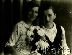Druga połowa lat 30. do 1941, Kozienice, Polska.
Portret dwóch dziewczyn z kwiatami.
Zdjęcie wykonane w atelier fotograficznym żydowskiego fotografa Chaima Bernemana. Przed wojną zakład mieścił się w Kozienicach na rogu ulic Warszawskiej i Maciejowickiej, przed wybuchem wojny albo już w czasie niemieckiej okupacji  został przeniesiony na ulicę Lubelską 13. Cała kolekcja jest datowana na okres od drugiej połowy lat 30-tych do roku 1941, kiedy Chaim Berneman wraz z rodziną został zesłany do obozu pracy w Wolanowie. Berneman zmarł po ucieczce z obozu.
Fot. Chaim Berneman (Chaim Berman), zbiory Ośrodka KARTA