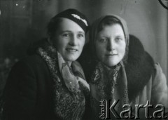 Druga połowa lat 30. do 1941, Kozienice, Polska.
Portret dwóch kobiet w zimowych ubraniach.
Zdjęcie wykonane w atelier fotograficznym żydowskiego fotografa Chaima Bernemana. Przed wojną zakład mieścił się w Kozienicach na rogu ulic Warszawskiej i Maciejowickiej, przed wybuchem wojny albo już w czasie niemieckiej okupacji  został przeniesiony na ulicę Lubelską 13. Cała kolekcja jest datowana na okres od drugiej połowy lat 30-tych do roku 1941, kiedy Chaim Berneman wraz z rodziną został zesłany do obozu pracy w Wolanowie. Berneman zmarł po ucieczce z obozu.
Fot. Chaim Berneman (Chaim Berman), zbiory Ośrodka KARTA