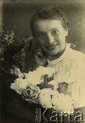 Druga połowa lat 30. do 1941, Kozienice, Polska.
Portret dziewczyny z kwiatami.
Zdjęcie wykonane w atelier fotograficznym żydowskiego fotografa Chaima Bernemana. Przed wojną zakład mieścił się w Kozienicach na rogu ulic Warszawskiej i Maciejowickiej, przed wybuchem wojny albo już w czasie niemieckiej okupacji  został przeniesiony na ulicę Lubelską 13. Cała kolekcja jest datowana na okres od drugiej połowy lat 30-tych do roku 1941, kiedy Chaim Berneman wraz z rodziną został zesłany do obozu pracy w Wolanowie. Berneman zmarł po ucieczce z obozu.
Fot. Chaim Berneman (Chaim Berman), zbiory Ośrodka KARTA