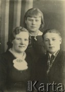 Druga połowa lat 30. do 1941, Kozienice, Polska.
Portret dwóch dziewczyn i chłopaka.
Zdjęcie wykonane w atelier fotograficznym żydowskiego fotografa Chaima Bernemana. Przed wojną zakład mieścił się w Kozienicach na rogu ulic Warszawskiej i Maciejowickiej, przed wybuchem wojny albo już w czasie niemieckiej okupacji  został przeniesiony na ulicę Lubelską 13. Cała kolekcja jest datowana na okres od drugiej połowy lat 30-tych do roku 1941, kiedy Chaim Berneman wraz z rodziną został zesłany do obozu pracy w Wolanowie. Berneman zmarł po ucieczce z obozu.
Fot. Chaim Berneman (Chaim Berman), zbiory Ośrodka KARTA