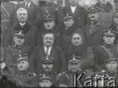 Druga połowa lat 30. do 1939, Kozienice, Polska.
Grupa osób - miejscowi notable i służby mundurowe.
Zdjęcie wykonane w atelier fotograficznym żydowskiego fotografa Chaima Bernemana. Przed wojną zakład mieścił się w Kozienicach na rogu ulic Warszawskiej i Maciejowickiej, przed wybuchem wojny albo już w czasie niemieckiej okupacji  został przeniesiony na ulicę Lubelską 13. Cała kolekcja jest datowana na okres od drugiej połowy lat 30-tych do roku 1941, kiedy Chaim Berneman wraz z rodziną został zesłany do obozu pracy w Wolanowie. Berneman zmarł po ucieczce z obozu.
Fot. Chaim Berneman (Chaim Berman), zbiory Ośrodka KARTA