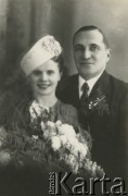 Druga połowa lat 30. do 1941, Kozienice, Polska.
Młoda para z bukietem kwiatów - fotografia ślubna.
Zdjęcie wykonane w atelier fotograficznym żydowskiego fotografa Chaima Bernemana. Przed wojną zakład mieścił się w Kozienicach na rogu ulic Warszawskiej i Maciejowickiej, przed wybuchem wojny albo już w czasie niemieckiej okupacji został przeniesiony na ulicę Lubelską 13. Cała kolekcja jest datowana na okres od drugiej połowy lat 30-tych do roku 1941, kiedy Chaim Berneman wraz z rodziną został zesłany do obozu pracy w Wolanowie. Berneman zmarł po ucieczce z obozu.
Fot. Chaim Berneman (Chaim Berman), zbiory Ośrodka KARTA