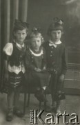 Druga połowa lat 30. do 1941, Kozienice, Polska.
Portret trzech dziewczynek z kokardami we włosach.
Zdjęcie wykonane w atelier fotograficznym żydowskiego fotografa Chaima Bernemana. Przed wojną zakład mieścił się w Kozienicach na rogu ulic Warszawskiej i Maciejowickiej, przed wybuchem wojny albo już w czasie niemieckiej okupacji został przeniesiony na ulicę Lubelską 13. Cała kolekcja jest datowana na okres od drugiej połowy lat 30-tych do roku 1941, kiedy Chaim Berneman wraz z rodziną został zesłany do obozu pracy w Wolanowie. Berneman zmarł po ucieczce z obozu.
Fot. Chaim Berneman (Chaim Berman), zbiory Ośrodka KARTA