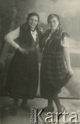 Druga połowa lat 30. do 1941, Kozienice, Polska.
Portret dwóch dziewczyn w strojach ludowych i w chustkach na głowach.
Zdjęcie wykonane w atelier fotograficznym żydowskiego fotografa Chaima Bernemana. Przed wojną zakład mieścił się w Kozienicach na rogu ulic Warszawskiej i Maciejowickiej, przed wybuchem wojny albo już w czasie niemieckiej okupacji został przeniesiony na ulicę Lubelską 13. Cała kolekcja jest datowana na okres od drugiej połowy lat 30-tych do roku 1941, kiedy Chaim Berneman wraz z rodziną został zesłany do obozu pracy w Wolanowie. Berneman zmarł po ucieczce z obozu.
Fot. Chaim Berneman (Chaim Berman), zbiory Ośrodka KARTA