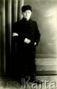 1939-1941, Kozienice, Polska.
Portret młodego mężczyzny z opaską na rękawie płaszcza.
Zdjęcie wykonane w atelier fotograficznym żydowskiego fotografa Chaima Bernemana. Przed wojną zakład mieścił się w Kozienicach na rogu ulic Warszawskiej i Maciejowickiej, przed wybuchem wojny albo już w czasie niemieckiej okupacji  został przeniesiony na ulicę Lubelską 13. Cała kolekcja jest datowana na okres od drugiej połowy lat 30-tych do roku 1941, kiedy Chaim Berneman wraz z rodziną został zesłany do obozu pracy w Wolanowie. Berneman zmarł po ucieczce z obozu.
Fot. Chaim Berneman (Chaim Berman), zbiory Ośrodka KARTA
