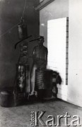 Druga połowa lat 30. do 1941, Kozienice, Polska.
Mężczyzna przy destylatorze.
Zdjęcie wykonane w atelier fotograficznym żydowskiego fotografa Chaima Bernemana. Przed wojną zakład mieścił się w Kozienicach na rogu ulic Warszawskiej i Maciejowickiej, przed wybuchem wojny albo już w czasie niemieckiej okupacji został przeniesiony na ulicę Lubelską 13. Cała kolekcja jest datowana na okres od drugiej połowy lat 30-tych do roku 1941, kiedy Chaim Berneman wraz z rodziną został zesłany do obozu pracy w Wolanowie. Berneman zmarł po ucieczce z obozu.
Fot. Chaim Berneman (Chaim Berman), zbiory Ośrodka KARTA