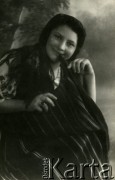 Druga połowa lat 30. do 1941, Kozienice, Polska.
Portret dziewczyny w chustce na głowie.
Zdjęcie wykonane w atelier fotograficznym żydowskiego fotografa Chaima Bernemana. Przed wojną zakład mieścił się w Kozienicach na rogu ulic Warszawskiej i Maciejowickiej, przed wybuchem wojny albo już w czasie niemieckiej okupacji został przeniesiony na ulicę Lubelską 13. Cała kolekcja jest datowana na okres od drugiej połowy lat 30-tych do roku 1941, kiedy Chaim Berneman wraz z rodziną został zesłany do obozu pracy w Wolanowie. Berneman zmarł po ucieczce z obozu.
Fot. Chaim Berneman (Chaim Berman), zbiory Ośrodka KARTA