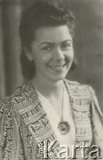 Druga połowa lat 30. do 1941, Kozienice, Polska.
Portret młodej kobiety w żakiecie i białej bluzce spiętej broszką.
Zdjęcie wykonane w atelier fotograficznym żydowskiego fotografa Chaima Bernemana. Przed wojną zakład mieścił się w Kozienicach na rogu ulic Warszawskiej i Maciejowickiej, przed wybuchem wojny albo już w czasie niemieckiej okupacji został przeniesiony na ulicę Lubelską 13. Cała kolekcja jest datowana na okres od drugiej połowy lat 30-tych do roku 1941, kiedy Chaim Berneman wraz z rodziną został zesłany do obozu pracy w Wolanowie. Berneman zmarł po ucieczce z obozu.
Fot. Chaim Berneman (Chaim Berman), zbiory Ośrodka KARTA