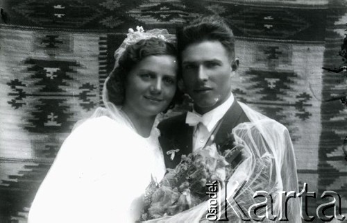 Druga połowa lat 30. do 1941, Kozienice, Polska.
Młoda para z bukietem kwiatów - fotografia ślubna.
Zdjęcie wykonane w atelier fotograficznym żydowskiego fotografa Chaima Bernemana. Przed wojną zakład mieścił się w Kozienicach na rogu ulic Warszawskiej i Maciejowickiej, przed wybuchem wojny albo już w czasie niemieckiej okupacji został przeniesiony na ulicę Lubelską 13. Cała kolekcja jest datowana na okres od drugiej połowy lat 30-tych do roku 1941, kiedy Chaim Berneman wraz z rodziną został zesłany do obozu pracy w Wolanowie. Berneman zmarł po ucieczce z obozu.
Fot. Chaim Berneman (Chaim Berman), zbiory Ośrodka KARTA