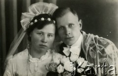 Druga połowa lat 30. do 1941, Kozienice, Polska.
Młoda para z bukietem kwiatów - fotografia ślubna.
Zdjęcie wykonane w atelier fotograficznym żydowskiego fotografa Chaima Bernemana. Przed wojną zakład mieścił się w Kozienicach na rogu ulic Warszawskiej i Maciejowickiej, przed wybuchem wojny albo już w czasie niemieckiej okupacji został przeniesiony na ulicę Lubelską 13. Cała kolekcja jest datowana na okres od drugiej połowy lat 30-tych do roku 1941, kiedy Chaim Berneman wraz z rodziną został zesłany do obozu pracy w Wolanowie. Berneman zmarł po ucieczce z obozu.
Fot. Chaim Berneman (Chaim Berman), zbiory Ośrodka KARTA