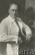 Druga połowa lat 30. do 1941, Kozienice, Polska.
Portret mężczyzny w białym fartuchu, z papierosem. Być może to lekarz albo aptekarz.
Zdjęcie wykonane w atelier fotograficznym żydowskiego fotografa Chaima Bernemana. Przed wojną zakład mieścił się w Kozienicach na rogu ulic Warszawskiej i Maciejowickiej, przed wybuchem wojny albo już w czasie niemieckiej okupacji został przeniesiony na ulicę Lubelską 13. Cała kolekcja jest datowana na okres od drugiej połowy lat 30-tych do roku 1941, kiedy Chaim Berneman wraz z rodziną został zesłany do obozu pracy w Wolanowie. Berneman zmarł po ucieczce z obozu.
Fot. Chaim Berneman (Chaim Berman), zbiory Ośrodka KARTA