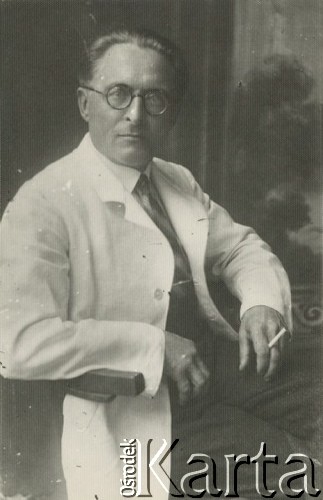 Druga połowa lat 30. do 1941, Kozienice, Polska.
Portret mężczyzny w białym fartuchu, z papierosem. Być może to lekarz albo aptekarz.
Zdjęcie wykonane w atelier fotograficznym żydowskiego fotografa Chaima Bernemana. Przed wojną zakład mieścił się w Kozienicach na rogu ulic Warszawskiej i Maciejowickiej, przed wybuchem wojny albo już w czasie niemieckiej okupacji został przeniesiony na ulicę Lubelską 13. Cała kolekcja jest datowana na okres od drugiej połowy lat 30-tych do roku 1941, kiedy Chaim Berneman wraz z rodziną został zesłany do obozu pracy w Wolanowie. Berneman zmarł po ucieczce z obozu.
Fot. Chaim Berneman (Chaim Berman), zbiory Ośrodka KARTA