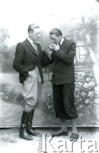 Druga połowa lat 30. do 1941, Kozienice, Polska.
Portret dwóch młodych mężczyzn w marynarkach, jasnych koszulach i krawatach. Jeden z mężczyzn przypala papierosa.
Zdjęcie wykonane w atelier fotograficznym żydowskiego fotografa Chaima Bernemana. Przed wojną zakład mieścił się w Kozienicach na rogu ulic Warszawskiej i Maciejowickiej, przed wybuchem wojny albo już w czasie niemieckiej okupacji został przeniesiony na ulicę Lubelską 13. Cała kolekcja jest datowana na okres od drugiej połowy lat 30-tych do roku 1941, kiedy Chaim Berneman wraz z rodziną został zesłany do obozu pracy w Wolanowie. Berneman zmarł po ucieczce z obozu.
Fot. Chaim Berneman (Chaim Berman), zbiory Ośrodka KARTA