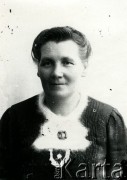 Druga połowa lat 30. do 1941, Kozienice, Polska.
Portret kobiety w moherowym szaliku spiętym broszką.
Zdjęcie wykonane w atelier fotograficznym żydowskiego fotografa Chaima Bernemana. Przed wojną zakład mieścił się w Kozienicach na rogu ulic Warszawskiej i Maciejowickiej, przed wybuchem wojny albo już w czasie niemieckiej okupacji został przeniesiony na ulicę Lubelską 13. Cała kolekcja jest datowana na okres od drugiej połowy lat 30-tych do roku 1941, kiedy Chaim Berneman wraz z rodziną został zesłany do obozu pracy w Wolanowie. Berneman zmarł po ucieczce z obozu.
Fot. Chaim Berneman (Chaim Berman), zbiory Ośrodka KARTA
