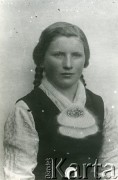 Druga połowa lat 30. do 1941, Kozienice, Polska.
Portret dziewczyny w moherowym szaliku spiętym broszką.
Zdjęcie wykonane w atelier fotograficznym żydowskiego fotografa Chaima Bernemana. Przed wojną zakład mieścił się w Kozienicach na rogu ulic Warszawskiej i Maciejowickiej, przed wybuchem wojny albo już w czasie niemieckiej okupacji został przeniesiony na ulicę Lubelską 13. Cała kolekcja jest datowana na okres od drugiej połowy lat 30-tych do roku 1941, kiedy Chaim Berneman wraz z rodziną został zesłany do obozu pracy w Wolanowie. Berneman zmarł po ucieczce z obozu.
Fot. Chaim Berneman (Chaim Berman), zbiory Ośrodka KARTA