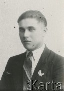 Druga połowa lat 30. do 1941, Kozienice, Polska.
Portret młodego mężczyzny w marynarce, białej koszuli i krawacie. W klapę marynarki jest wpięta broszka w kształcie postaci z parasolką i psa.
Zdjęcie wykonane w atelier fotograficznym żydowskiego fotografa Chaima Bernemana. Przed wojną zakład mieścił się w Kozienicach na rogu ulic Warszawskiej i Maciejowickiej, przed wybuchem wojny albo już w czasie niemieckiej okupacji został przeniesiony na ulicę Lubelską 13. Cała kolekcja jest datowana na okres od drugiej połowy lat 30-tych do roku 1941, kiedy Chaim Berneman wraz z rodziną został zesłany do obozu pracy w Wolanowie. Berneman zmarł po ucieczce z obozu.
Fot. Chaim Berneman (Chaim Berman), zbiory Ośrodka KARTA