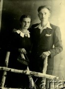 Druga połowa lat 30. do 1941, Kozienice, Polska.
Portret młodej kobiety w czarnej sukience z białym kołnierzykiem oraz mężczyzny w garniturze.
Zdjęcie wykonane w atelier fotograficznym żydowskiego fotografa Chaima Bernemana. Przed wojną zakład mieścił się w Kozienicach na rogu ulic Warszawskiej i Maciejowickiej, przed wybuchem wojny albo już w czasie niemieckiej okupacji został przeniesiony na ulicę Lubelską 13. Cała kolekcja jest datowana na okres od drugiej połowy lat 30-tych do roku 1941, kiedy Chaim Berneman wraz z rodziną został zesłany do obozu pracy w Wolanowie. Berneman zmarł po ucieczce z obozu.
Fot. Chaim Berneman (Chaim Berman), zbiory Ośrodka KARTA