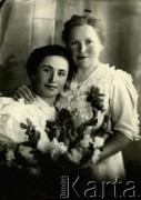 Druga połowa lat 30. do 1941, Kozienice, Polska.
Portret dwóch młodych kobiet z kwiatami.
Zdjęcie wykonane w atelier fotograficznym żydowskiego fotografa Chaima Bernemana. Przed wojną zakład mieścił się w Kozienicach na rogu ulic Warszawskiej i Maciejowickiej, przed wybuchem wojny albo już w czasie niemieckiej okupacji został przeniesiony na ulicę Lubelską 13. Cała kolekcja jest datowana na okres od drugiej połowy lat 30-tych do roku 1941, kiedy Chaim Berneman wraz z rodziną został zesłany do obozu pracy w Wolanowie. Berneman zmarł po ucieczce z obozu.
Fot. Chaim Berneman (Chaim Berman), zbiory Ośrodka KARTA