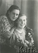 Druga połowa lat 30. do 1941, Kozienice, Polska.
Portret dwóch młodych kobiet z kwiatami.
Zdjęcie wykonane w atelier fotograficznym żydowskiego fotografa Chaima Bernemana. Przed wojną zakład mieścił się w Kozienicach na rogu ulic Warszawskiej i Maciejowickiej, przed wybuchem wojny albo już w czasie niemieckiej okupacji został przeniesiony na ulicę Lubelską 13. Cała kolekcja jest datowana na okres od drugiej połowy lat 30-tych do roku 1941, kiedy Chaim Berneman wraz z rodziną został zesłany do obozu pracy w Wolanowie. Berneman zmarł po ucieczce z obozu.
Fot. Chaim Berneman (Chaim Berman), zbiory Ośrodka KARTA