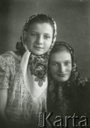 Druga połowa lat 30. do 1941, Kozienice, Polska.
Portret dwóch dziewczynek w chustkach.
Zdjęcie wykonane w atelier fotograficznym żydowskiego fotografa Chaima Bernemana. Przed wojną zakład mieścił się w Kozienicach na rogu ulic Warszawskiej i Maciejowickiej, przed wybuchem wojny albo już w czasie niemieckiej okupacji został przeniesiony na ulicę Lubelską 13. Cała kolekcja jest datowana na okres od drugiej połowy lat 30-tych do roku 1941, kiedy Chaim Berneman wraz z rodziną został zesłany do obozu pracy w Wolanowie. Berneman zmarł po ucieczce z obozu.
Fot. Chaim Berneman (Chaim Berman), zbiory Ośrodka KARTA