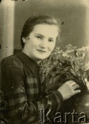 Druga połowa lat 30. do 1941, Kozienice, Polska.
Portret dziewczyny z kwiatami.
Zdjęcie wykonane w atelier fotograficznym żydowskiego fotografa Chaima Bernemana. Przed wojną zakład mieścił się w Kozienicach na rogu ulic Warszawskiej i Maciejowickiej, przed wybuchem wojny albo już w czasie niemieckiej okupacji został przeniesiony na ulicę Lubelską 13. Cała kolekcja jest datowana na okres od drugiej połowy lat 30-tych do roku 1941, kiedy Chaim Berneman wraz z rodziną został zesłany do obozu pracy w Wolanowie. Berneman zmarł po ucieczce z obozu.
Fot. Chaim Berneman (Chaim Berman), zbiory Ośrodka KARTA