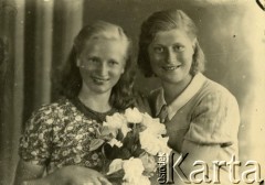 Druga połowa lat 30. do 1941, Kozienice, Polska.
Portret dwóch dziewczyn z kwiatami.
Zdjęcie wykonane w atelier fotograficznym żydowskiego fotografa Chaima Bernemana. Przed wojną zakład mieścił się w Kozienicach na rogu ulic Warszawskiej i Maciejowickiej, przed wybuchem wojny albo już w czasie niemieckiej okupacji został przeniesiony na ulicę Lubelską 13. Cała kolekcja jest datowana na okres od drugiej połowy lat 30-tych do roku 1941, kiedy Chaim Berneman wraz z rodziną został zesłany do obozu pracy w Wolanowie. Berneman zmarł po ucieczce z obozu.
Fot. Chaim Berneman (Chaim Berman), zbiory Ośrodka KARTA