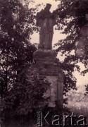 Druga połowa lat 30. do 1939, Kozienice, Polska.
Kapliczka wśród drzew.
Zdjęcie wykonane w atelier fotograficznym żydowskiego fotografa Chaima Bernemana. Przed wojną zakład mieścił się w Kozienicach na rogu ulic Warszawskiej i Maciejowickiej, tuż przed wybuchem wojny albo już w czasie niemieckiej okupacji  został przeniesiony na ulicę Lubelską 13. Cała kolekcja jest datowana na okres od drugiej połowy lat 30-tych do roku 1941, kiedy Chaim Berneman wraz z rodziną został zesłany do obozu pracy w Wolanowie. Berneman zmarł na tyfus po ucieczce z obozu.
Fot. Chaim Berneman (Chaim Berman), zbiory Ośrodka KARTA