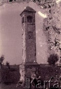 Druga połowa lat 30. do 1939, Kozienice, Polska.
Mężczyzna siedzący na ziemi przed kapliczką.
Zdjęcie wykonane w atelier fotograficznym żydowskiego fotografa Chaima Bernemana. Przed wojną zakład mieścił się w Kozienicach na rogu ulic Warszawskiej i Maciejowickiej, tuż przed wybuchem wojny albo już w czasie niemieckiej okupacji  został przeniesiony na ulicę Lubelską 13. Cała kolekcja jest datowana na okres od drugiej połowy lat 30-tych do roku 1941, kiedy Chaim Berneman wraz z rodziną został zesłany do obozu pracy w Wolanowie. Berneman zmarł na tyfus po ucieczce z obozu.
Fot. Chaim Berneman (Chaim Berman), zbiory Ośrodka KARTA