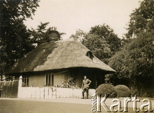 Lipiec 1943, okolice Thetford, Anglia, Wielka Brytania.
Podpułkownik Roman Jan Gilewski przed domem pokrytym strzechą postawionym przy bramie wjazdowej do obozu dla polskich żołnierzy. R. Gilewski (ur. 1902 – zm. 1969 lub 1971) - przed wojną kierownik Referatu Studiów Taktycznych w Dowództwie Broni Pancernych, sekretarz Generalnej Komisji Regulaminowej Broni Pancernej. We wrześniu 1939 roku przedostał się do Rumunii, potem do Francji. W Szkocji został wychowawcą podchorążych, m.in. w Bulford, Catterick Camp. 
Fot. NN, zbiory Ośrodka KARTA, przekazał Marek Kostrzewski