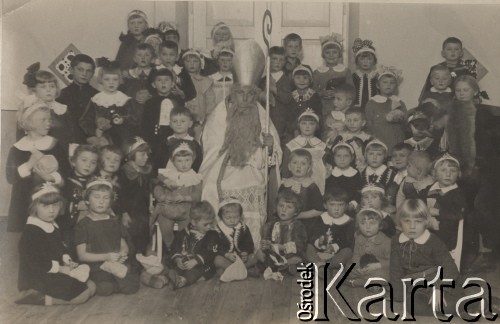 Brak daty, brak miejsca.
Przedszkole - grupa dzieci w asyście Świętego Mikołaja. Dzieci mają na głowach ozdobne opaski z gwiazdkami.
Fot. Józef Tarań, zbiory Ośrodka KARTA, kolekcję zdjęć przekazała Lucyna Kumiszczo