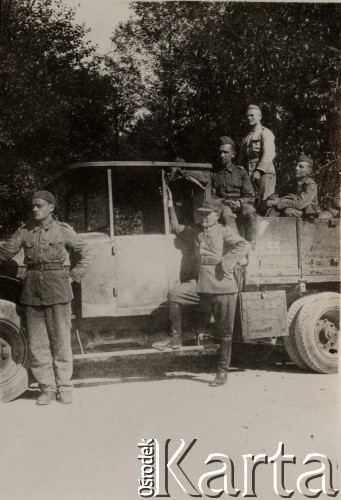 1935, Brześć, woj. poleskie, Polska.
Twierdza brzeska - codzienne szkolenie żołnierzy służby zasadniczej, oficerów oraz podchorążych rezerwy. Żołnierze stoją przy samochodzie wojskowym, w tle widoczne są drzewa.
Fot. Józef Tarań, Fundacja Ośrodka KARTA kolekcję zdjęć przekazała Lucyna Kumiszczo