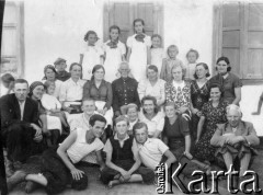 Sierpień 1940, Smirnowka, Kustanajska obł., Kazachstan, ZSRR.
Polacy deportowani do Kazachstanu. Duża grupa ludzi przed budynkiem. Na zdjęciu w górnym rzędzie od lewej: Barbara Sobocińska, Z. Bobulówna, Janina Bobulówna, Jadzia (Danusia) Kolińska, NN, Andrzej Sobociński; poniżej 4. od prawej Kolińska (zmarła na Syberii), pozostali w rzędzie nierozpoznani; 3. od prawej (klęczy, uśmiecha się) Irena Sobocińska; na dole od lewej: Ryszard Teodorowicz, Zdzisław Burzyński, Stanisław Koliński; nad nim (uśmiecha się) Mira Durko. Niewskazana, jest na zdjęciu: Barbara Stankiewicz.
Fot. NN, zbiory Ośrodka KARTA, udostępnił Wacław Kurman
