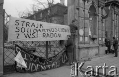 Listopad 1981, Warszawa, Polska.
Uniwersytet Warszawski - strajk okupacyjny studentów solidaryzujących się ze studentami Wyższej Szkoły Inżynierskiej w Radomiu. Mężczyźni zawieszają transparenty na uniwersyteckiej Bramie Głównej.
Fot. NN, zbiory Ośrodka KARTA/Independent Polish Agency (IPA) przekazał Józef Lebenbaum

