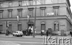 Luty 1981, Warszawa, Polska.
Uniwersytet Warszawski - strajk okupacyjny studentów solidaryzujących się ze studentami w Łodzi. Przechodnie czytają informację o strajku zawieszoną na drzwiach wejściowych gmachu uczelni przy Krakowskim Przedmieściu. Flagi państwowe wywieszone w oknach, transparent: 