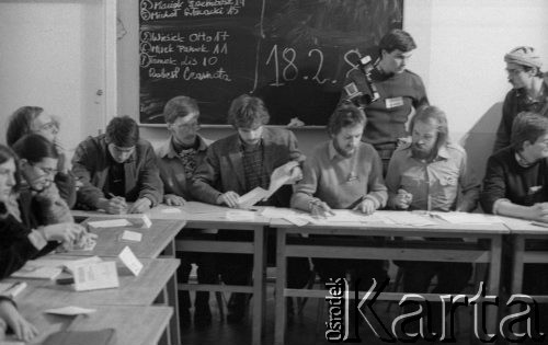 Luty 1981, Warszawa, Polska.
Wydział Polonistyki Uniwersytetu Warszawskiego - strajk okupacyjny studentów solidaryzujących się ze studentami w Łodzi. Wybory, pierwszy od prawej siedzi Tomasz Lis, NN, Maciej Geller, Maciej Strzembosz (?), Mirosław Panek (?). Po prawej stronie stoi Wojciech Ferens. Na tablicy widoczne są nazwiska kandydatów oraz wyniki głosowania.
Fot. NN, zbiory Ośrodka KARTA/Independent Polish Agency (IPA) przekazał Józef Lebenbaum