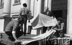 Po 13.05.1981, Warszawa, Polska.
Przygotowania przed Kościołem św. Anny do mszy zorganizowanej po zamachu na papieża Jana Pawła II - mężczyźni rozkładają płótna.
Fot. NN, zbiory Ośrodka KARTA/Independent Polish Agency (IPA) przekazał Józef Lebenbaum