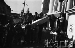Po 13.05.1981, Warszawa, Polska.
Przygotowania przed Kościołem św. Anny do mszy  zorganizowanej po zamachu na Jana Pawła II - mężczyźni ustawiają krzyż. Drugi z prawej strony stoi Mirosław Odorowski (z flagą w rękach). W tle - architektura Starego Miasta.  
Fot. NN, zbiory Ośrodka KARTA/Independent Polish Agency (IPA) przekazał Józef Lebenbaum