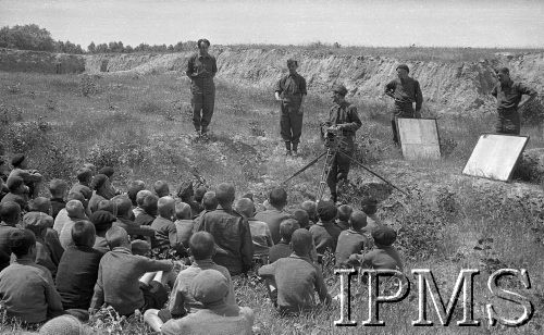 Maj 1942, Wrewskoje, Uzbekistan, ZSRR
Filmowcy robiący zdjęcia dzieciom siedzącym na ziemi.
Fot. inż. Ostrowski, Instytut Polski im. Gen. Sikorskiego w Londynie [album negatywowy A-I ROSJA] - płachta 48