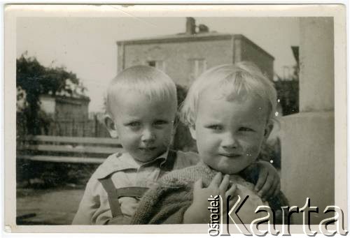 Lato 1943, Warszawa, Generalne Gubernatorstwo.
Grochów, rodzeństwo Elżbieta i Adam Jędrychowie na podwórku, w tle budynki przy ul. Wzorcowej.
Fot. NN, kolekcja Elżbiety Jędrych-Pordes, zbiory Ośrodka KARTA.