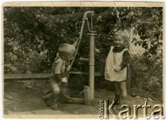 Lato 1944, Warszawa, Generalne Gubernatorstwo.
Grochów, rodzeństwo Elżbieta i Adam Jędrychowie na podwórku przy studni.
Fot. NN, kolekcja Elżbiety Jędrych-Pordes, zbiory Ośrodka KARTA.