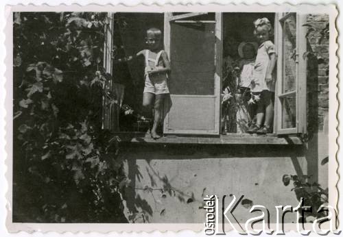 Lato 1947, Warszawa, Polska.
Grochów, Maria Jędrych z dziećmi: Elżbietą (1. z prawej), Adamem i Anną w oknie mieszkania.
Fot. NN, kolekcja Elżbiety Jędrych-Pordes, zbiory Ośrodka KARTA.
