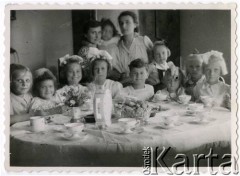 Lato 1947, Warszawa, Polska.
Grochów, grupa dzieci przy stole, przyjęcie komunijne w domu pp. Błaszczyków. Przy stole od lewej: Wanda Kalinowska, Jolanta Błaszczyk, Elżbieta Błaszczyk, Danuta Głuchowska, NN, Maria Głuchowska, Zofia Gawronkiewicz. Stoją (od lewej): Eugenia Błaszczyk z córką Jolantą i siostrą oraz Elżbieta Jędrych.  
Fot. NN, kolekcja Elżbiety Jędrych-Pordes, zbiory Ośrodka KARTA.
