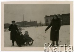 Zima 1954, Warszawa, Polska.
Grochów, ulica Tarczowa, Maria Jędrych na sankach z dziećmi: Elżbietą (w środku), Adamem i Anną. W głębi widoczne budynki przy ulicy Rozłuckiej i dom przy ulicy Wzorcowej.
Fot. NN, kolekcja Elżbiety Jędrych-Pordes, zbiory Ośrodka KARTA.