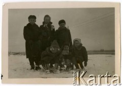 Zima 1954, Warszawa, Polska.
Elżbieta (stoi w środku), Adam (1. z lewej) i Anna (na dole z lewej) Jędrychowie na sankach z Wiesławem, Leszkiem i Andrzejem Krzywcami.
Fot. NN, kolekcja Elżbiety Jędrych-Pordes, zbiory Ośrodka KARTA.
