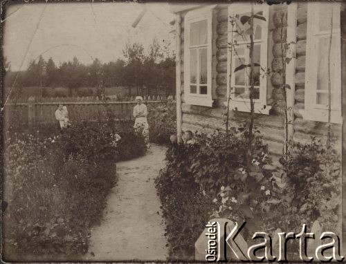 1916, leśnictwo Pristanskoje, Wyksa okolice, gubernia włodzimierska, Rosja.
W ogrodzie przy leśniczówce, w głębi od lewej stoją: Feliksa Skorupska z Irenką Skorupską na ręku, Paula Ewerman oraz w krzakach pod domem Ferdynand Skorupski i Benek Ewerman.
Fot. NN, zbiory Ośrodka KARTA Fot. NN, zbiory Ośrodka KARTA, album Wacława Skorupskiego udostępniła Agata Witerska