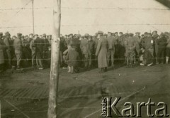 1917, Szczypiorno k/Kalisza, Polska.
Niemiecki obóz dla internowanych jeńców wojennych - polskich legionistów w Szczypiornie. Widok zza drutu kolczastego na tłum jeńców na terenie obozu.
Fot. NN, zbiory Ośrodka KARTA, Pogotowie Archiwalne [PAF_004], przekazała Anna Stańczykowska