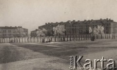 Ok. 1918, brak miejsca.
Zima, widok na budynki otoczone ogrodzeniem i znajdujące się przed nimi oszronione drzewa. Przy ogrodzeniu idzie trzech mężczyzn z wózkiem.
Fot. NN, zbiory Ośrodka KARTA, Pogotowie Archiwalne [PAF_004], udostępniła Anna Stańczykowska